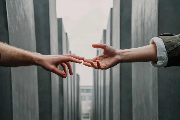 Hands clasped across generations, symbolizing the transmission of intergenerational trauma through the nervous system